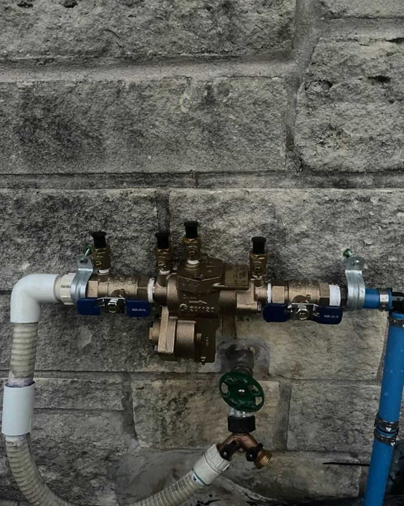 New brass reduced pressure backflow assembly mounted on a stone wall